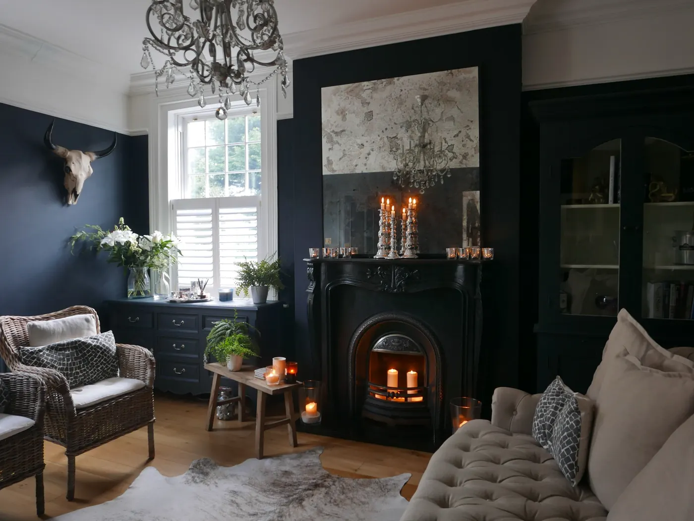 A navy-painted sitting room with a cast-iron fireplace