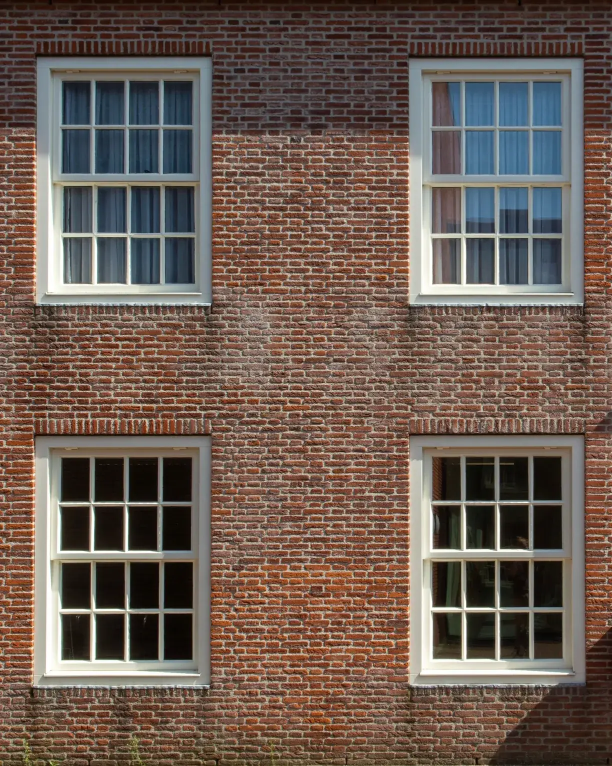 A brick house front with white-painted sash windows
